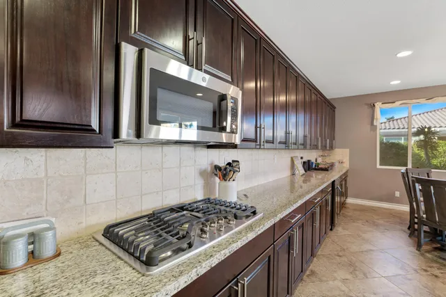a kitchen with stainless steel appliances granite countertop a stove a sink and a microwave