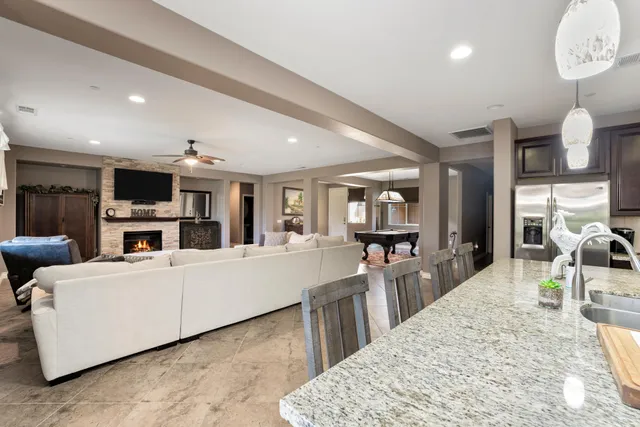 a living room with furniture a table and kitchen view