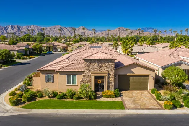 a front view of a house with a yard and trees