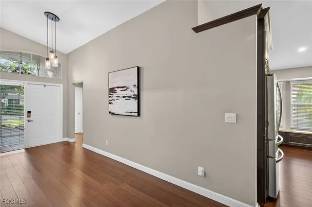 a view of a hallway with wooden floor and a window