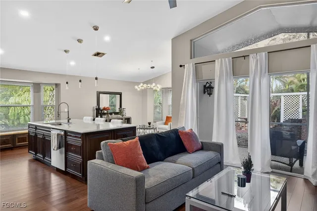 a living room with stainless steel appliances granite countertop furniture and a large window
