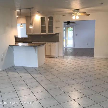 a view of a kitchen with kitchen island granite countertop a sink and a stove top oven