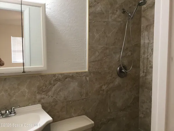 a bathroom with a toilet sink and shower