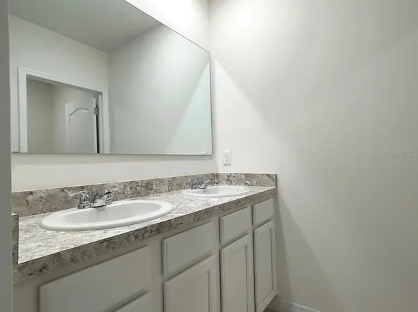 a bathroom with a granite countertop sink and a mirror
