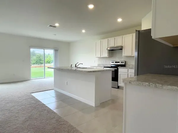a kitchen with stainless steel appliances granite countertop a stove a sink a refrigerator and a oven