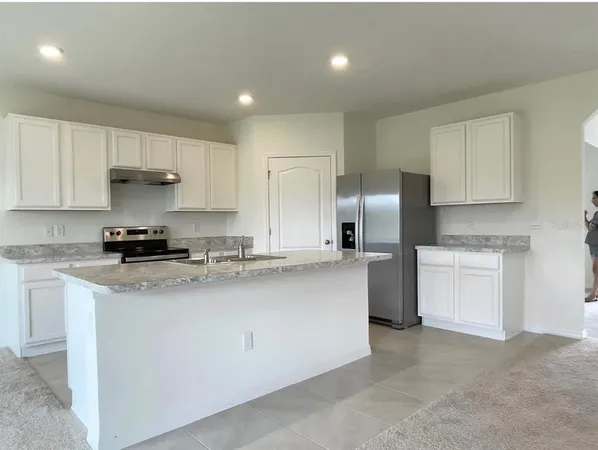 a kitchen with stainless steel appliances granite countertop a refrigerator sink and stove