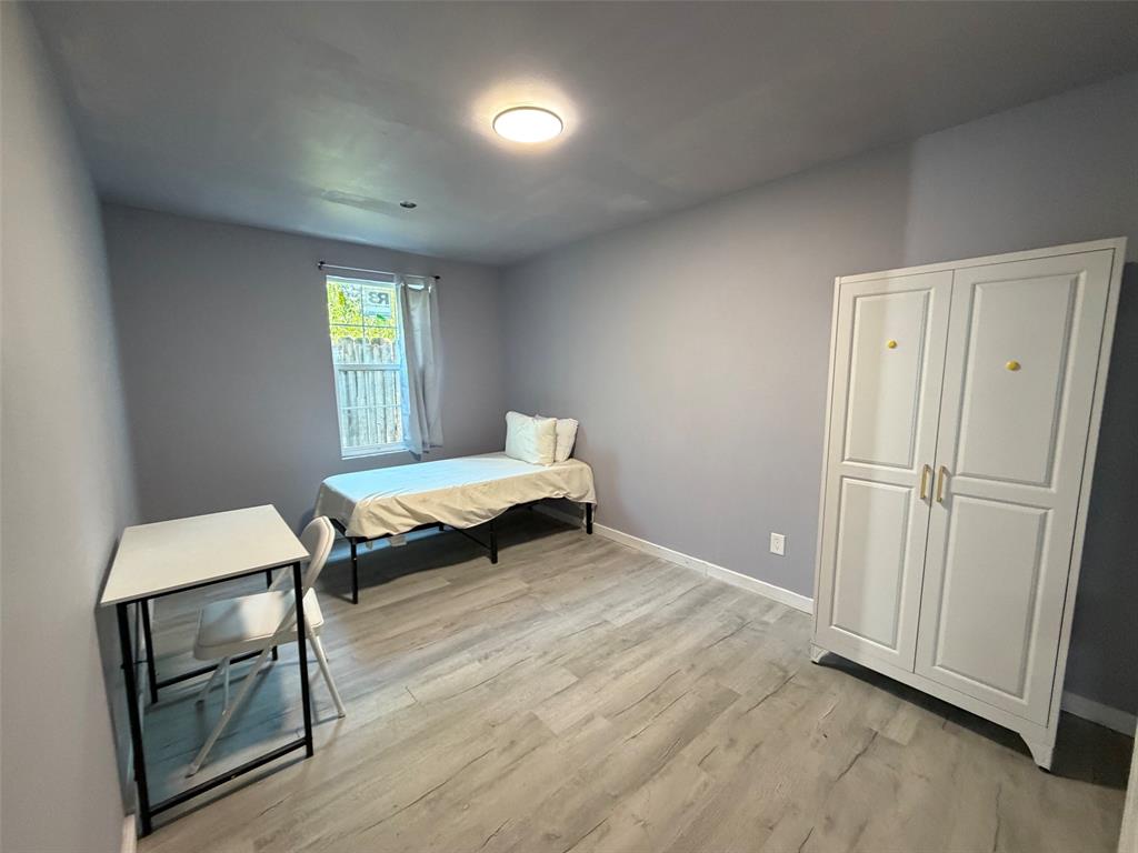 513 Shawnee Trace Grand Prairie, TX 75051 - Photo 14 of 32 Room featuring gray walls, wood-finish flooring, and a single window