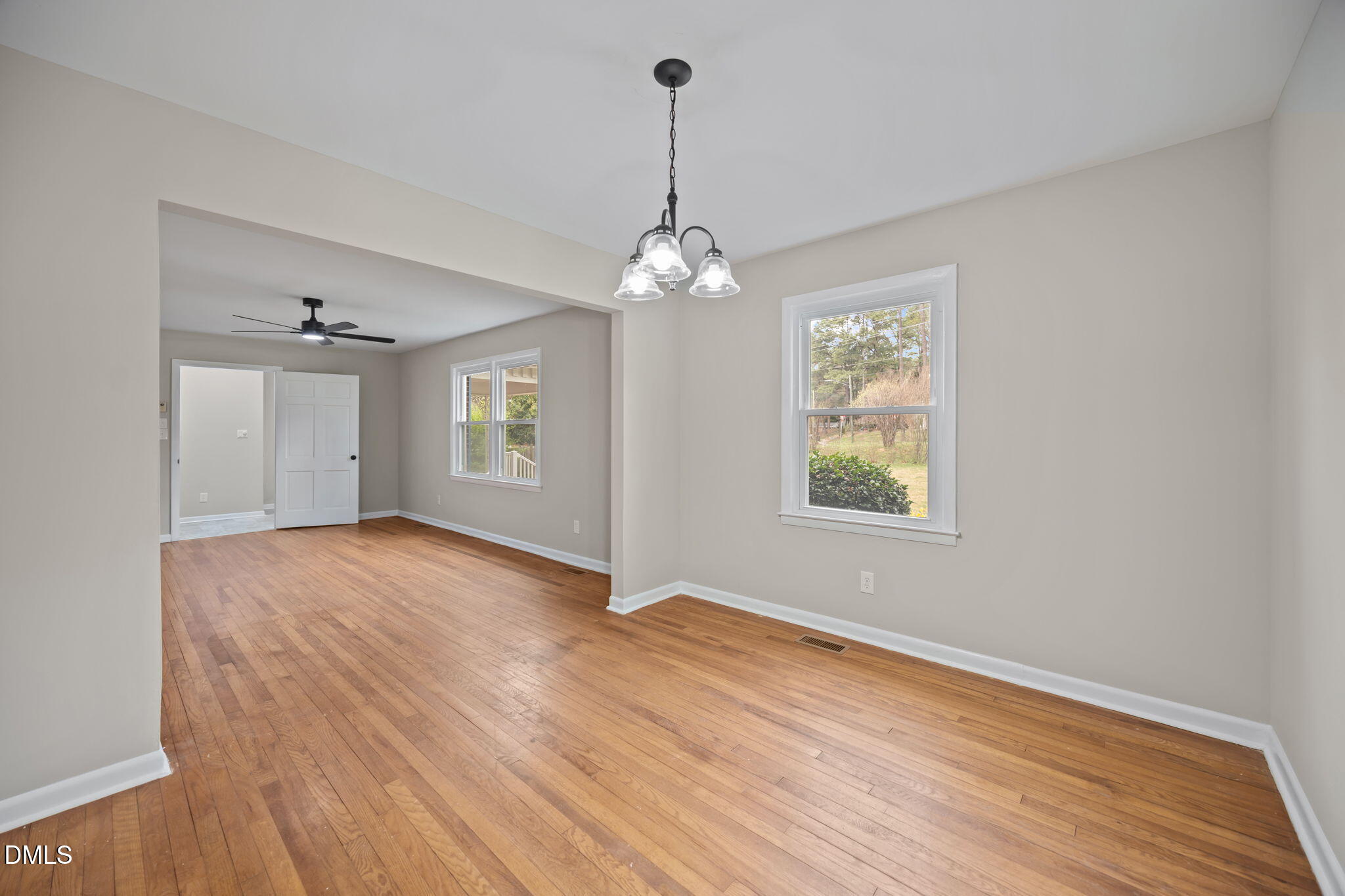 637 Buck Jones Road Raleigh, NC 27606 - Photo 7 of 32 a view of an empty room with window and wooden floor