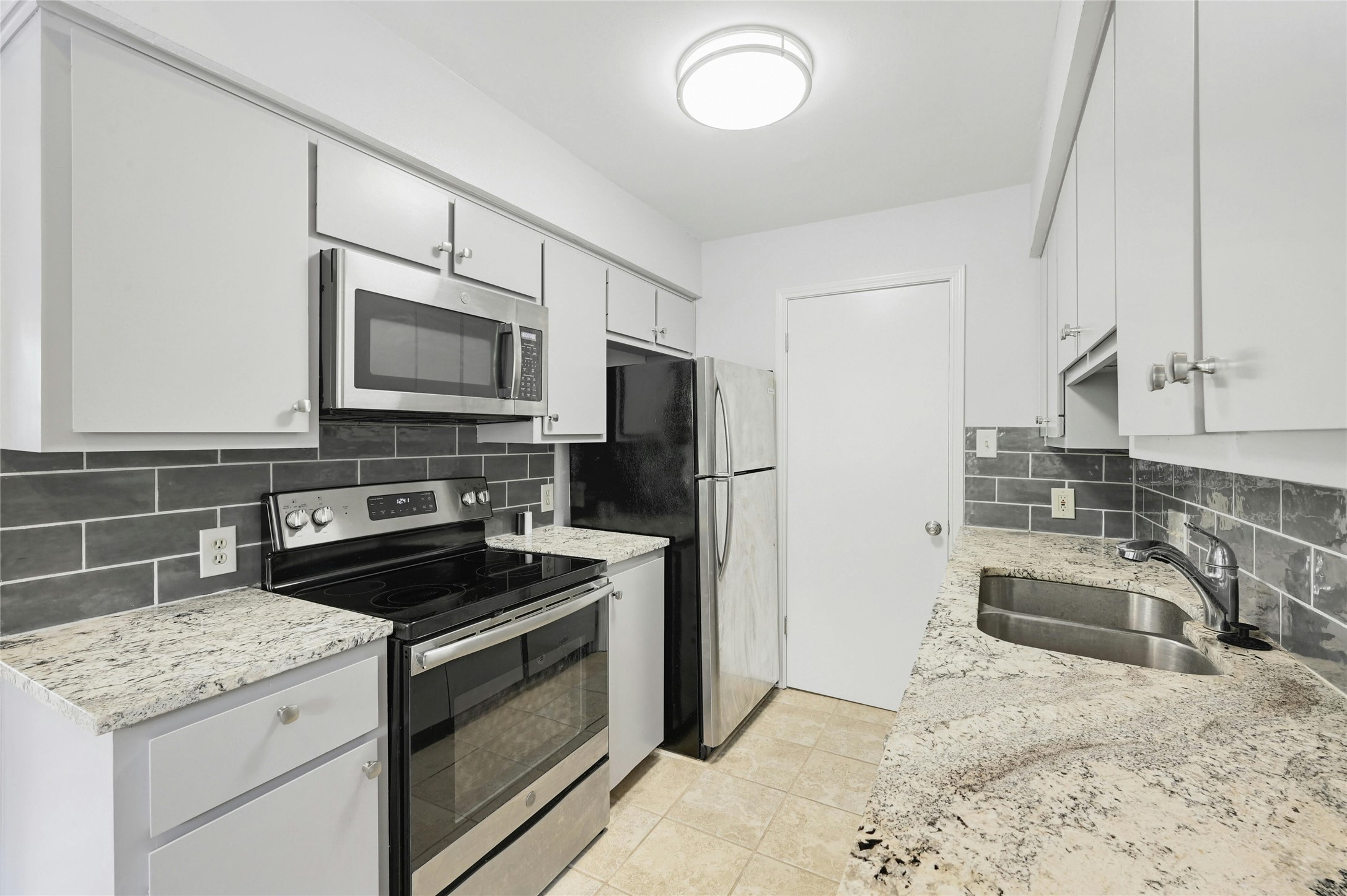 9226 Jollyville Road, Unit 221 Austin, TX 78759 - Photo 1 of 20 Culinary delights await in this modern kitchen, featuring sleek stainless steel appliances and abundant counter space.