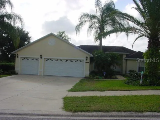 a view of a house with a yard and palm trees