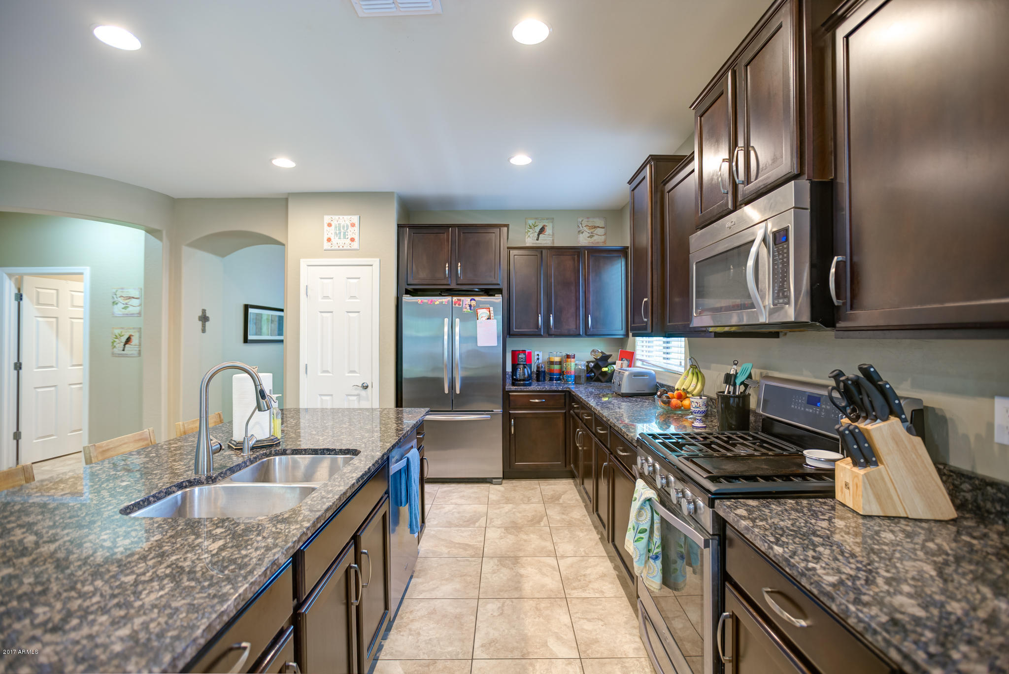 3515 East Ivanhoe Street Gilbert, AZ 85295 - Photo 5 of 49 a kitchen with granite countertop stainless steel appliances a sink stove top oven and cabinets