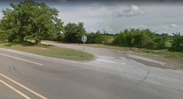 a view of a field with trees in background