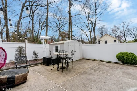 a view of a patio with table and chairs with wooden fence and plants