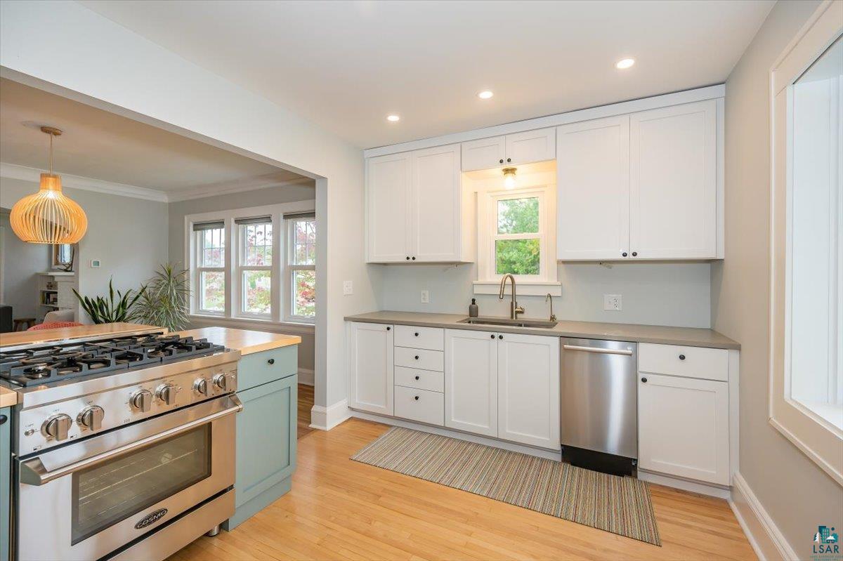5401 Otsego Street Duluth, MN 55804 - Photo 11 of 36 Kitchen featuring a stainless steel range, light wood-finish flooring, white cabinetry, integrated sink with modern faucet, and recessed lighting