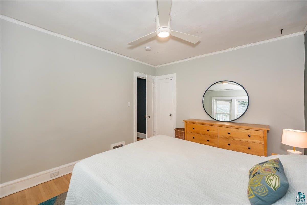 5401 Otsego Street Duluth, MN 55804 - Photo 16 of 36 Light-toned walls with white trim, wood-finish flooring, and a ceiling fan with integrated lighting
