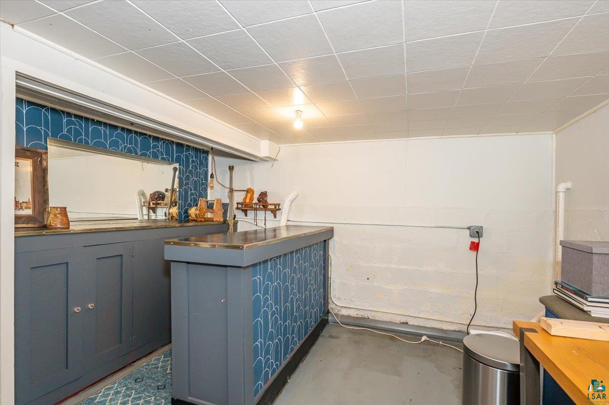 5401 Otsego Street Duluth, MN 55804 - Photo 18 of 36 Custom-built bar area featuring a blue patterned facade, built-in cabinetry, and a mirrored backsplash