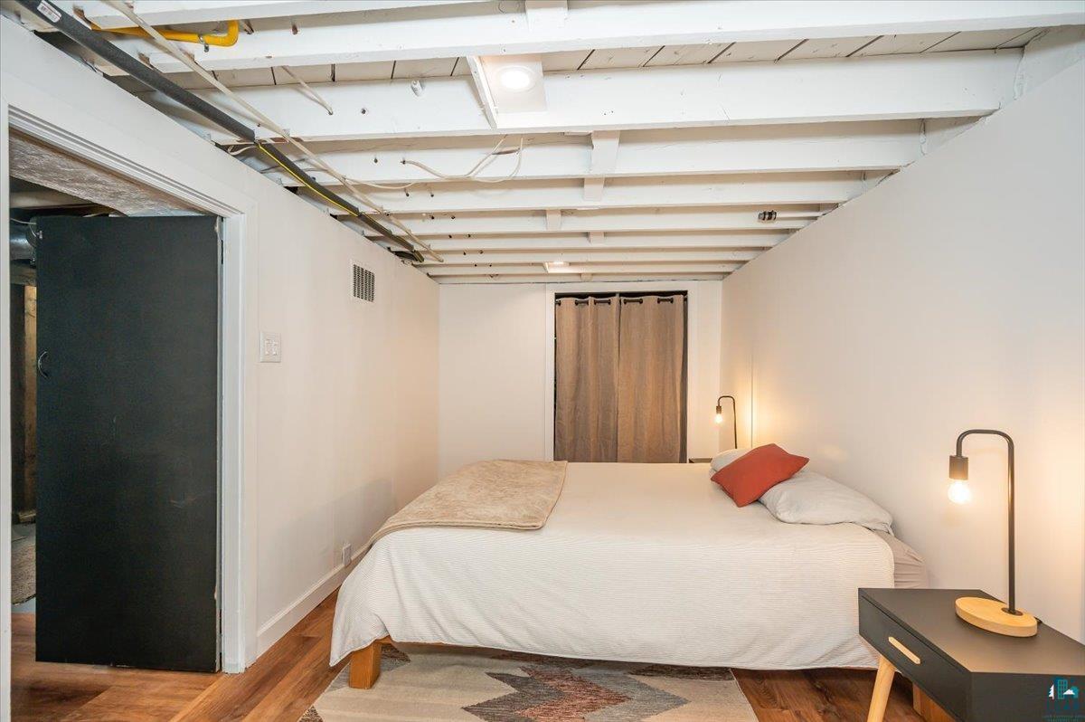 5401 Otsego Street Duluth, MN 55804 - Photo 20 of 36 Room featuring wood-finish flooring, exposed white ceiling joists, white walls, and recessed lighting