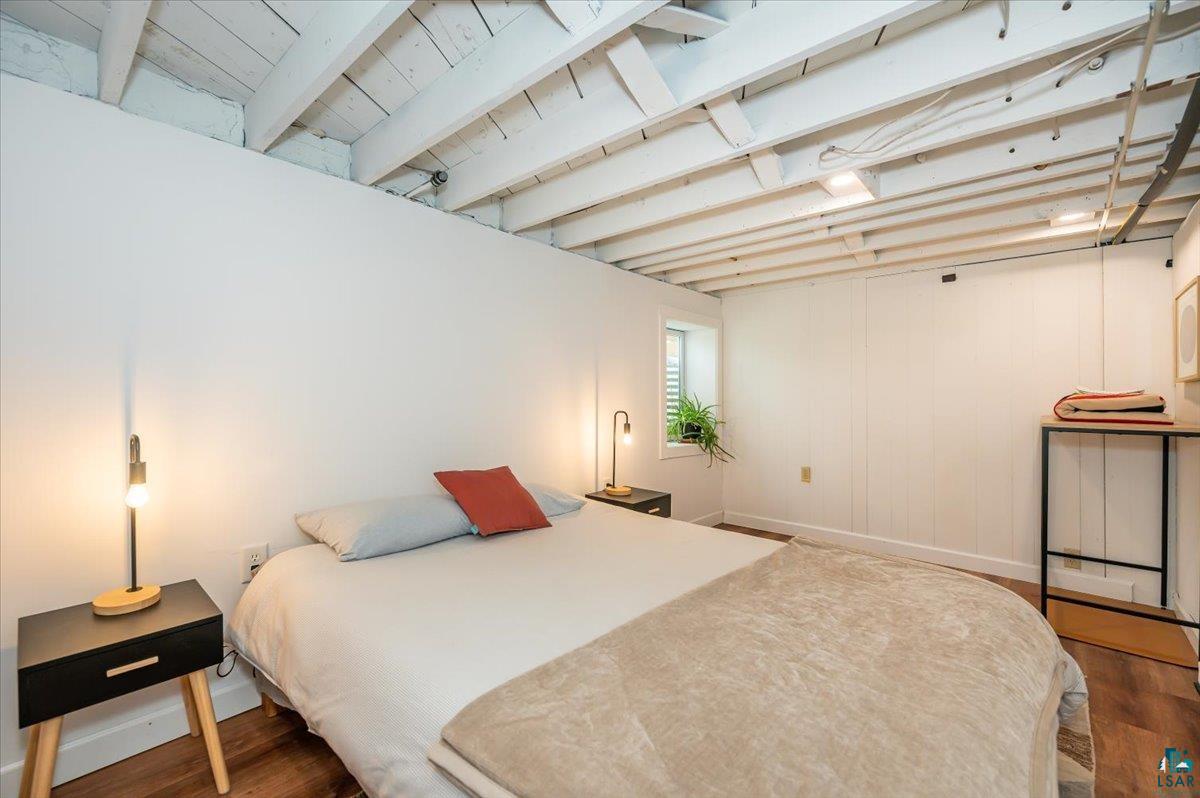 5401 Otsego Street Duluth, MN 55804 - Photo 21 of 36 Room featuring wood-finish flooring, exposed white ceiling joists, and white panel walls