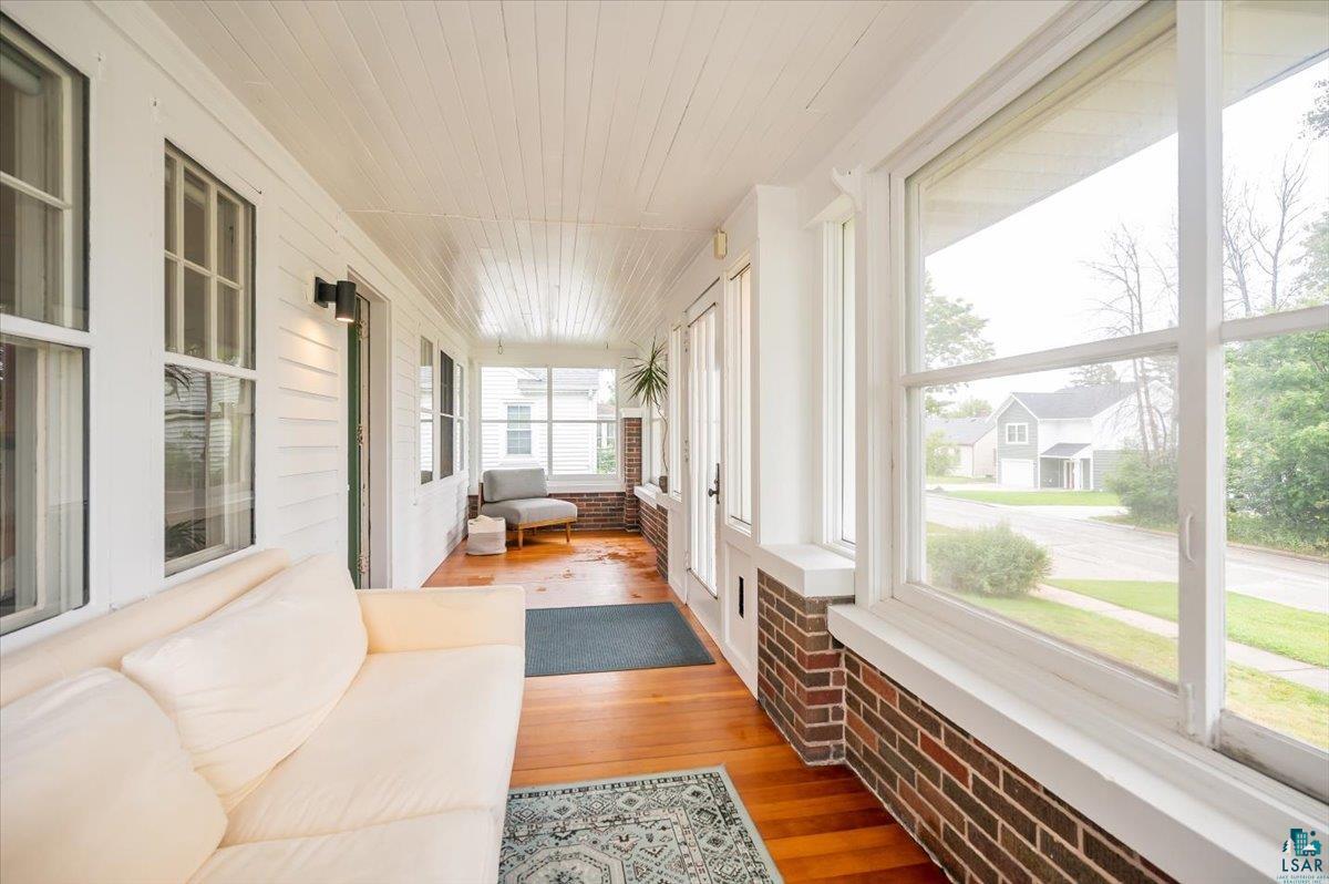 5401 Otsego Street Duluth, MN 55804 - Photo 3 of 36 Enclosed porch featuring wood-finish flooring, white shiplap ceiling, brick half-walls, and multiple large windows
