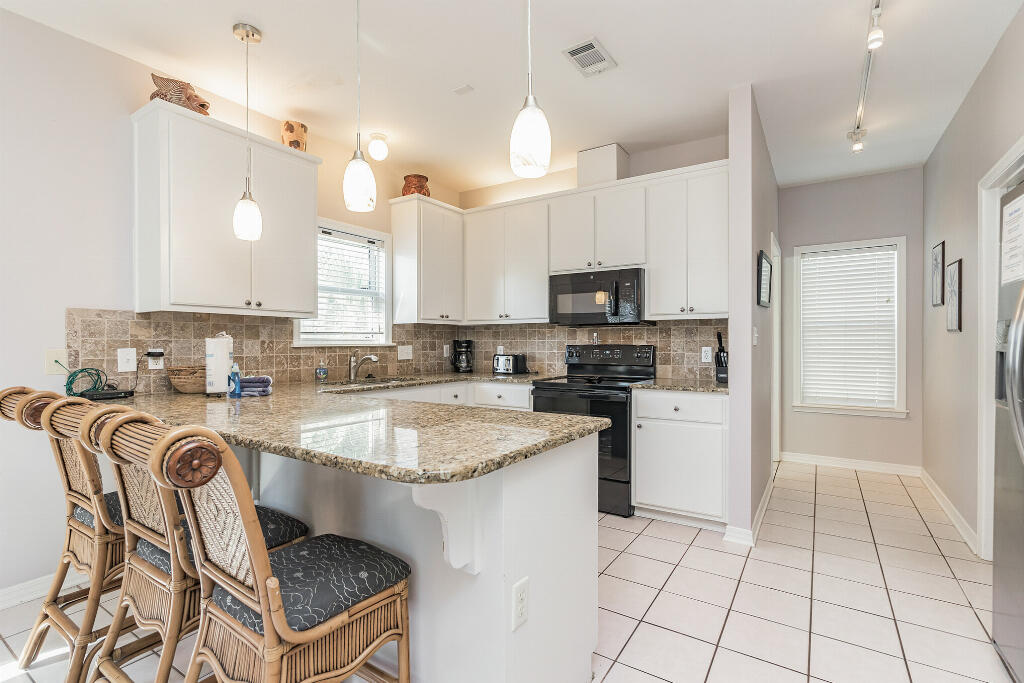 159 Gulfside Way Miramar Beach, FL 32550 - Photo 7 of 17 a kitchen with kitchen island granite countertop a stove a sink and a refrigerator