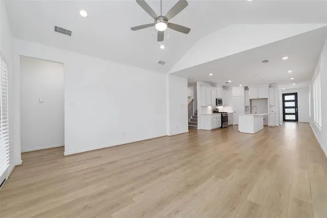a view of an empty room and kitchen view