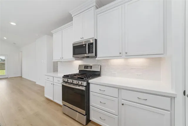 a kitchen with white cabinets stainless steel appliances and sink