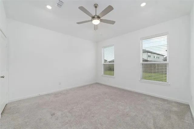 an empty room with a window and a fan