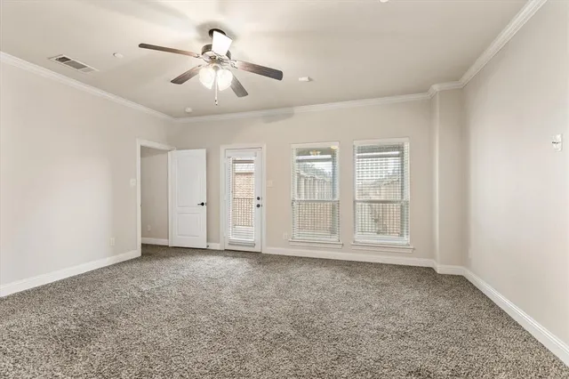 an empty room with chandelier fan and windows
