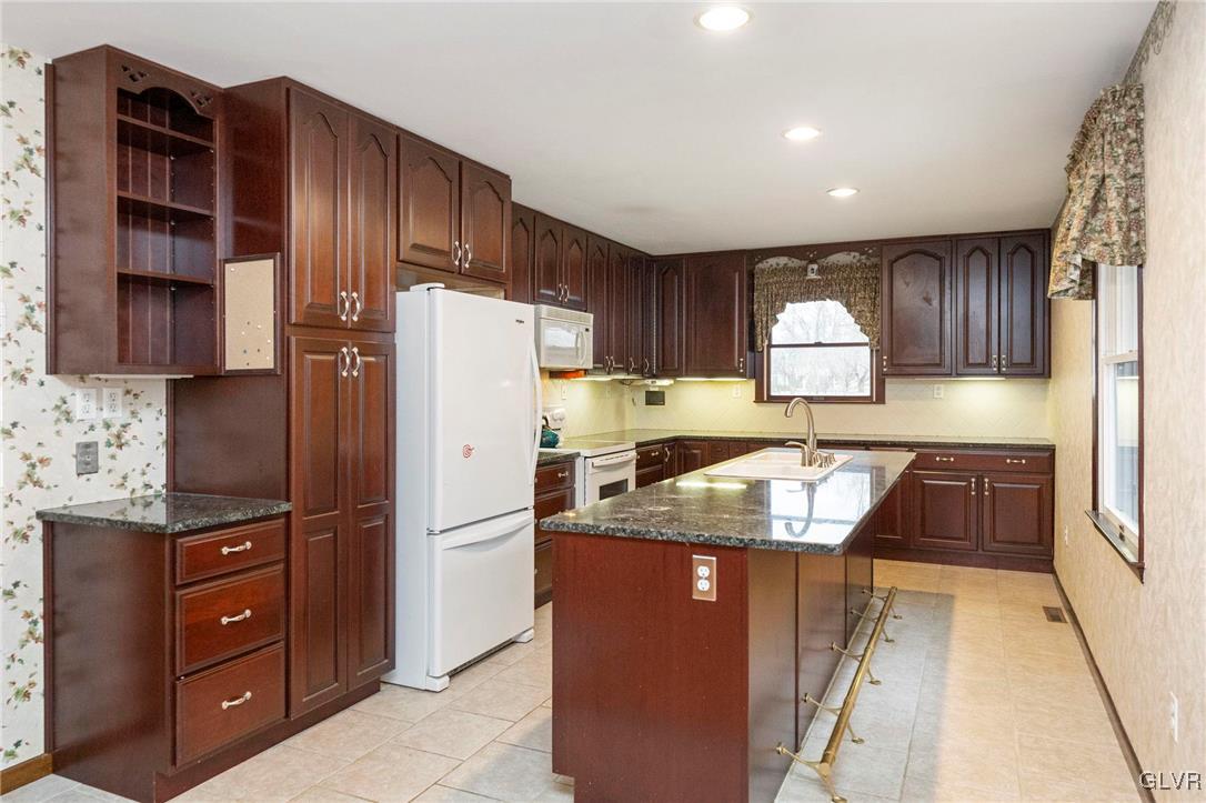 7058 Limerick Square Bethlehem, PA 18017 - Photo 11 of 30 a kitchen with granite countertop a refrigerator and a stove top oven