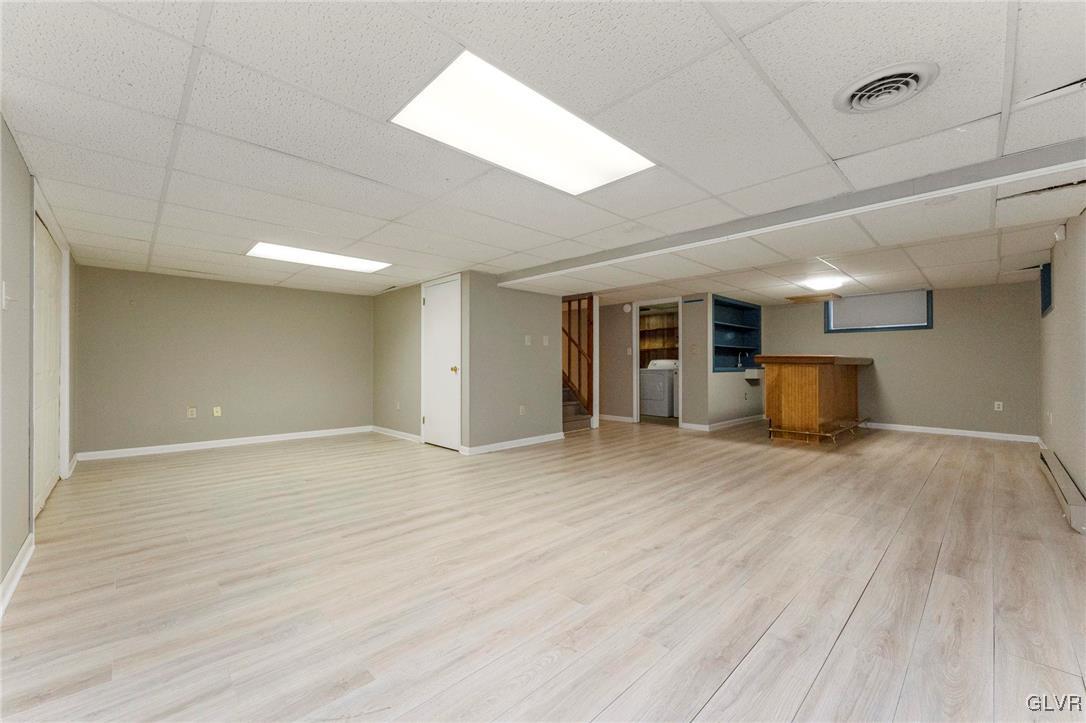 7058 Limerick Square Bethlehem, PA 18017 - Photo 23 of 30 an empty room with wooden floor and kitchen view