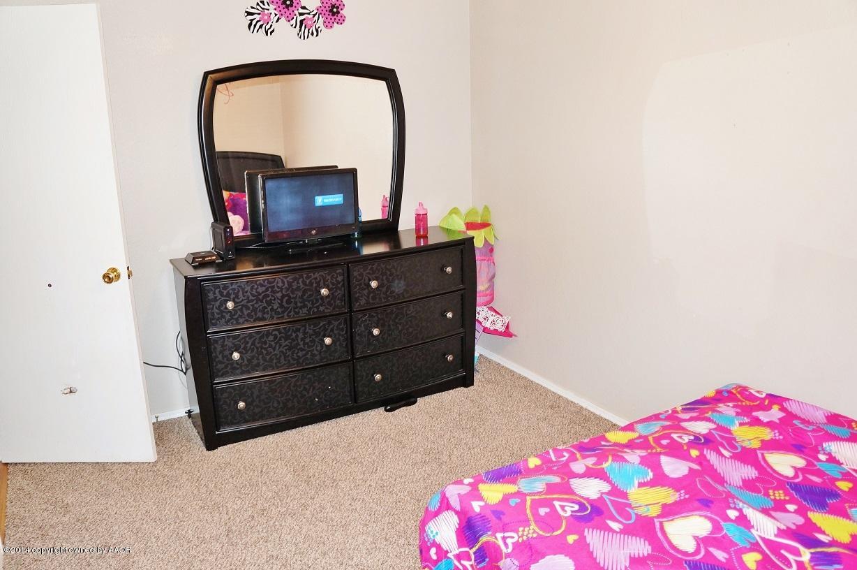4910 Capulin Lane Amarillo, TX 79110 - Photo 9 of 17 a bedroom with a bed and a flat screen tv