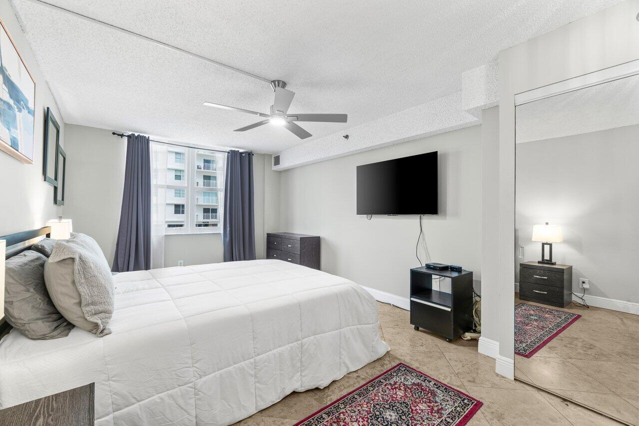 4511 South Ocean Boulevard, Unit 106 Highland Beach, FL 33487 - Photo 17 of 37 a bedroom with a bed and a flat screen tv
