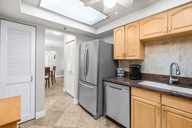 a kitchen with granite countertop a refrigerator and a sink