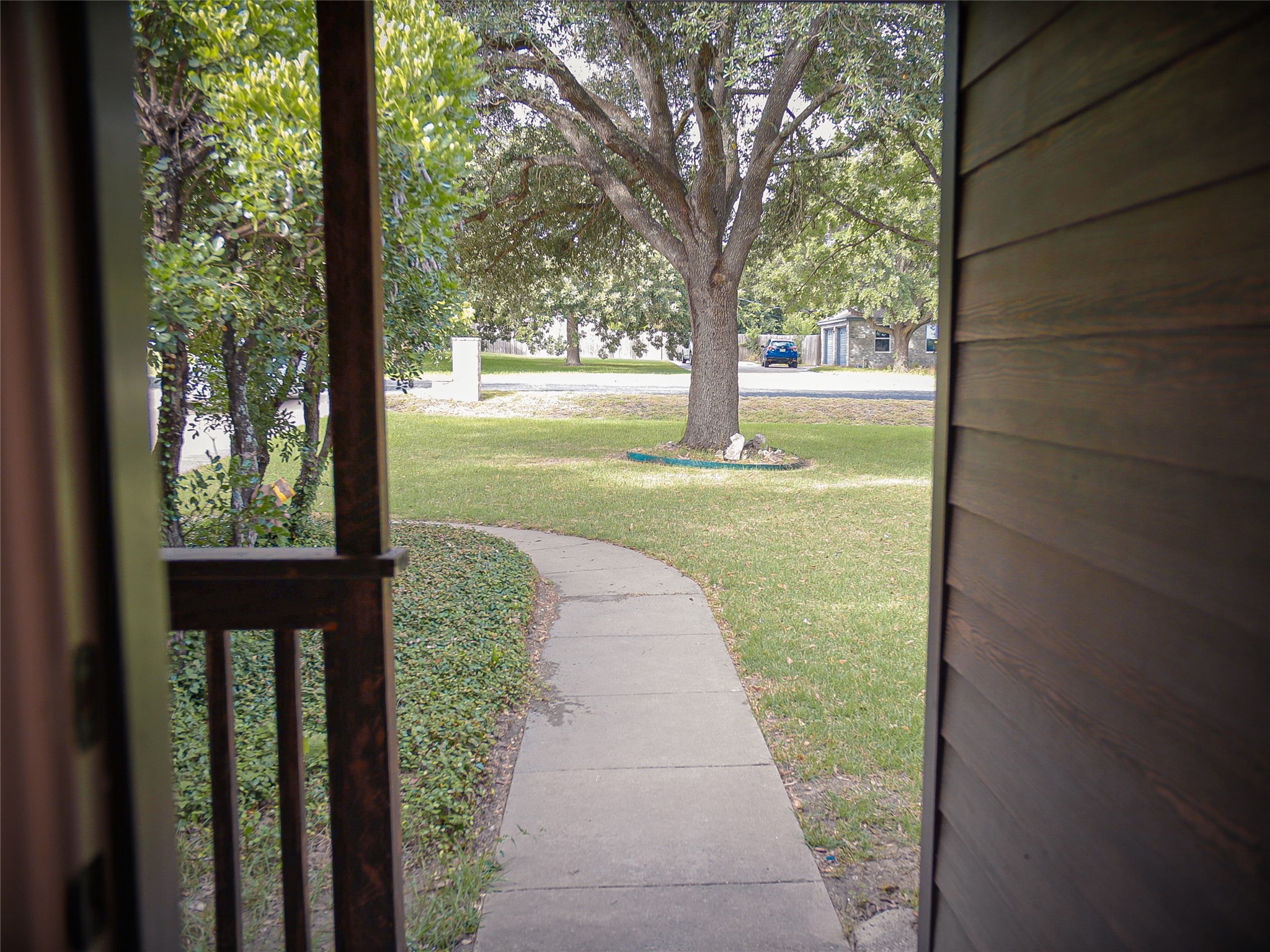 1612 Buttercup Road Pflugerville, TX 78660 - Photo 3 of 16 A graceful paved pathway leads through lush greenery to a welcoming home entrance.