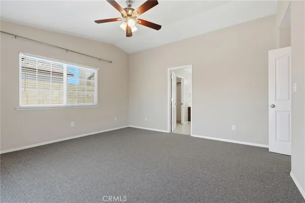 a view of an empty room with chandelier fan