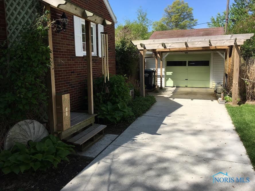 711 Ransom Street Maumee, OH 43537 - Photo 15 of 17 This brick bungalow has a newer concrete driveway and detached garage with a charming wood pergola.