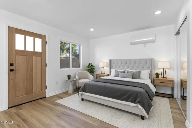 a bedroom with a bed and wooden floor