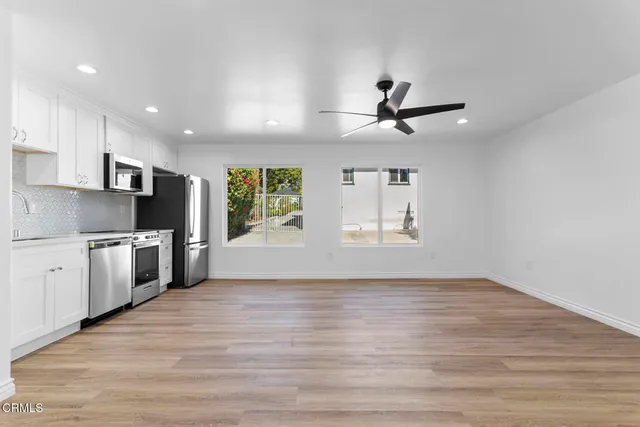 a view of kitchen with sink microwave refrigerator and cabinets