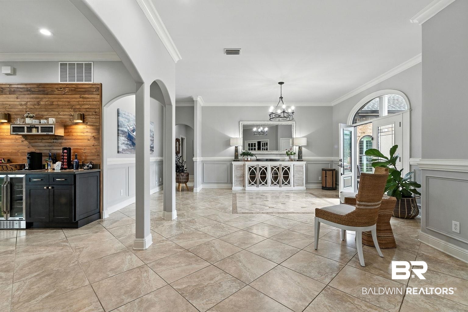 23357 Carnoustie Drive Foley, AL 36535 - Photo 6 of 99 Entrance foyer with crown molding, beverage cooler, arched walkways, bar area, and wainscoting