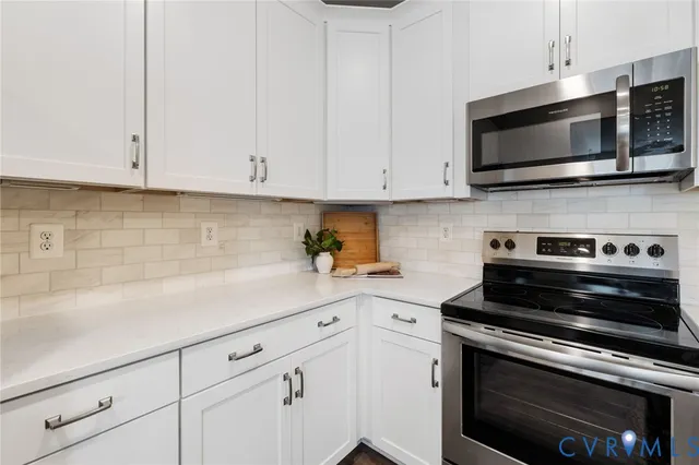 a kitchen with white cabinets and stainless steel appliances