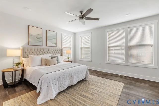 a bedroom with a large bed couch and a large window