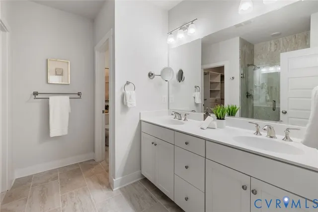 a bathroom with a double vanity sink mirror and shower