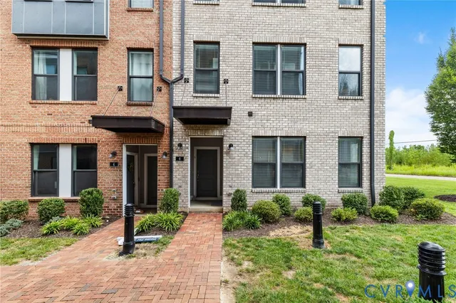 front view of a brick house with a yard