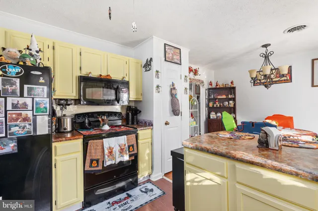a kitchen with stainless steel appliances a stove refrigerator sink and microwave