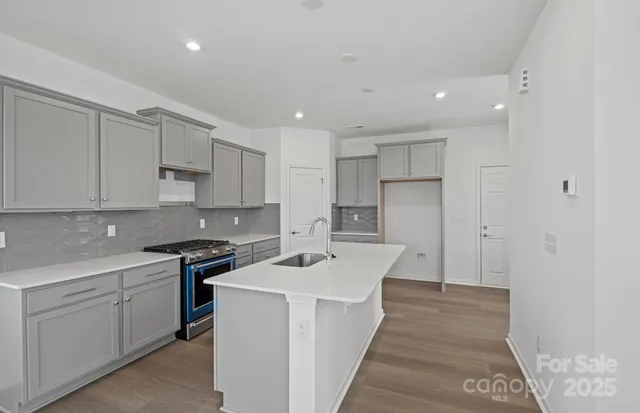 a kitchen that has a sink in it and white stainless steel appliances