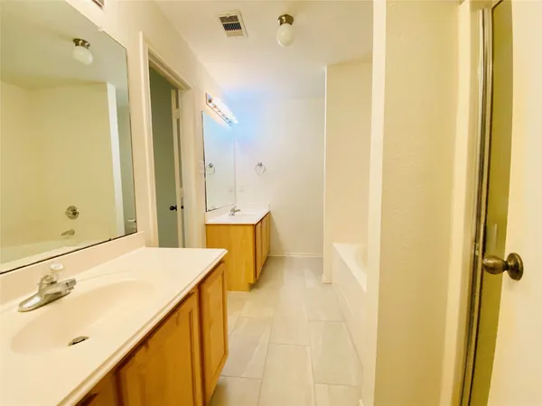 a bathroom with a tub sink and mirror