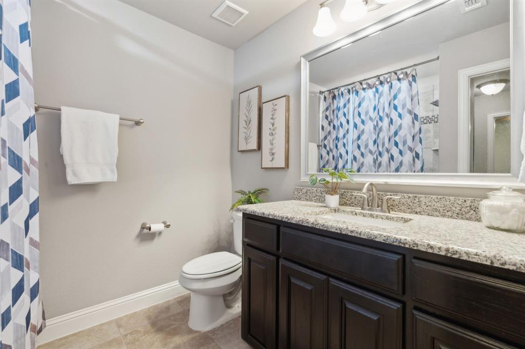 2610 Sunset Bay Lane Nevada, TX 75173 - Photo 26 of 34 a bathroom with a granite countertop sink a toilet and a mirror