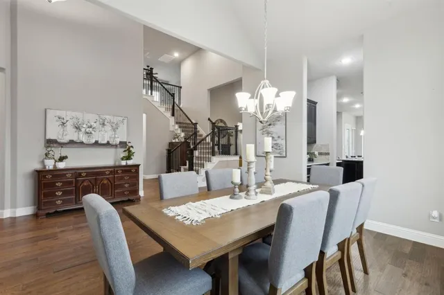 a dining room with furniture a chandelier and wooden floor