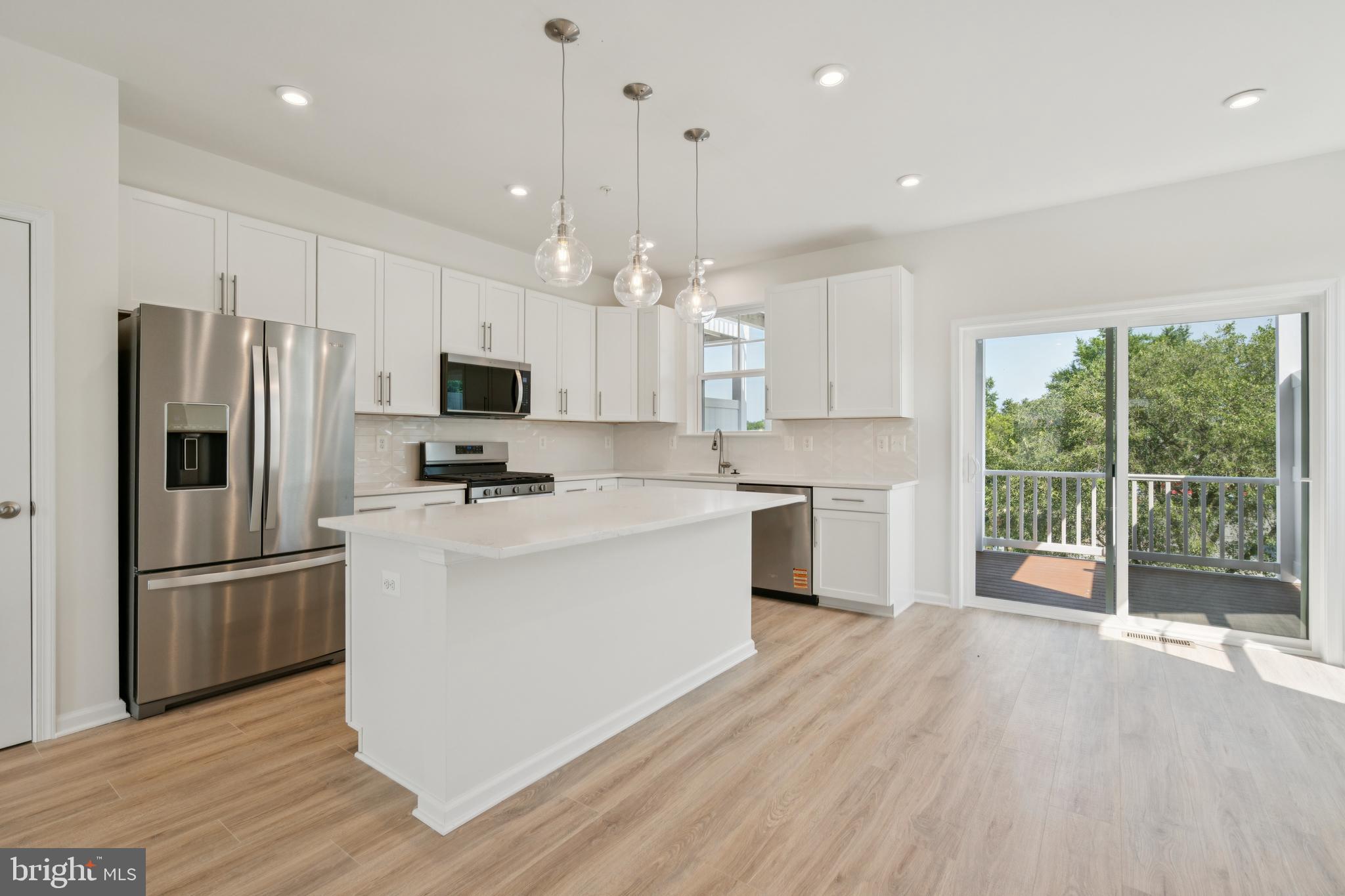 2 Riverside Wharf Cambridge, MD 21613 - Photo 5 of 38 a kitchen with white cabinets and stainless steel appliances