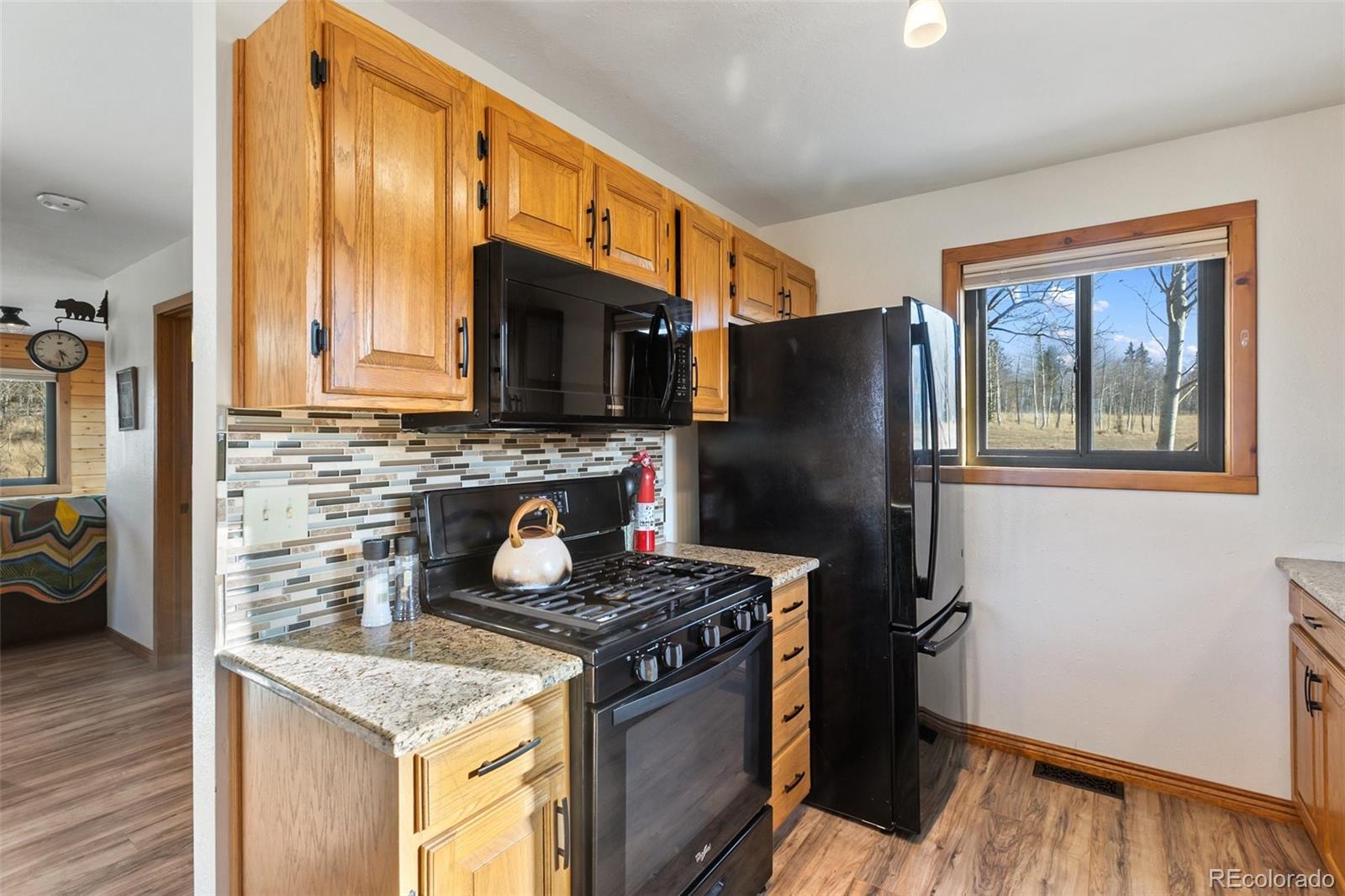 2387 Buffalo Ridge Road Como, CO 80456 - Photo 11 of 50 a kitchen with granite countertop a refrigerator stove and wooden floor